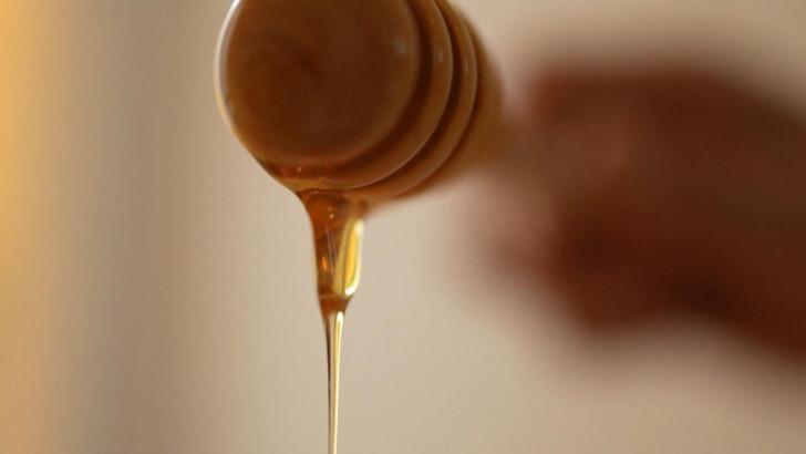 Cuiller à miel en bois d'où coule le nectar